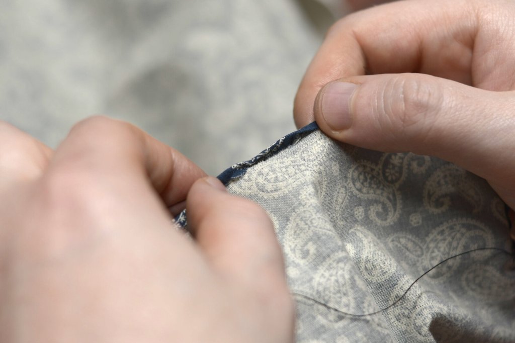 Gently pull the hem stitches taut.