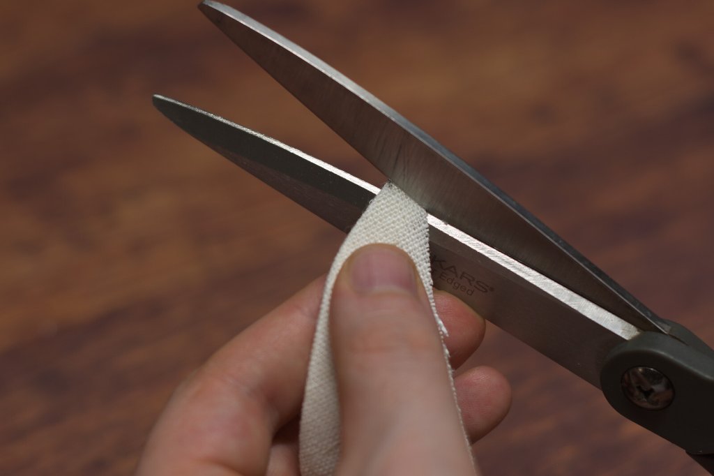 Cutting fabric with scissors.
