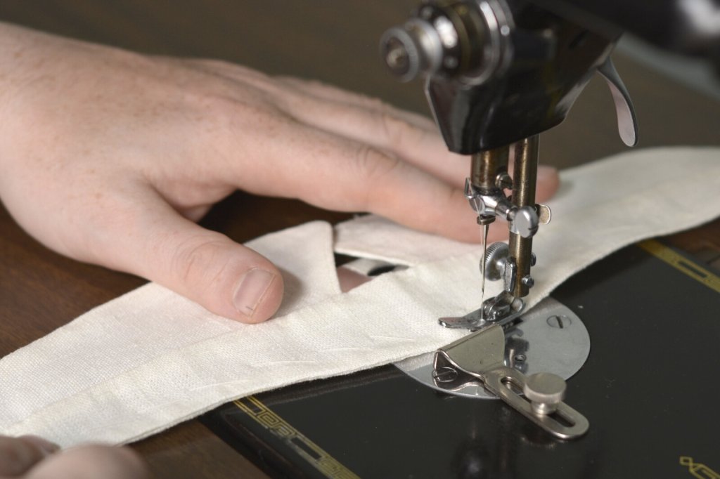 Top stitching a shirt collar with a sewing machine.