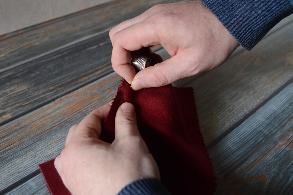 Using a tailor's thimble and needle.