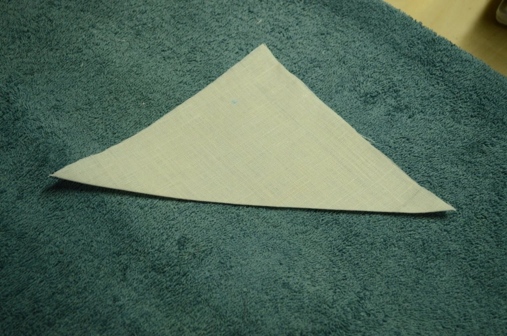 Fold and press the linen square in half, diagonally.