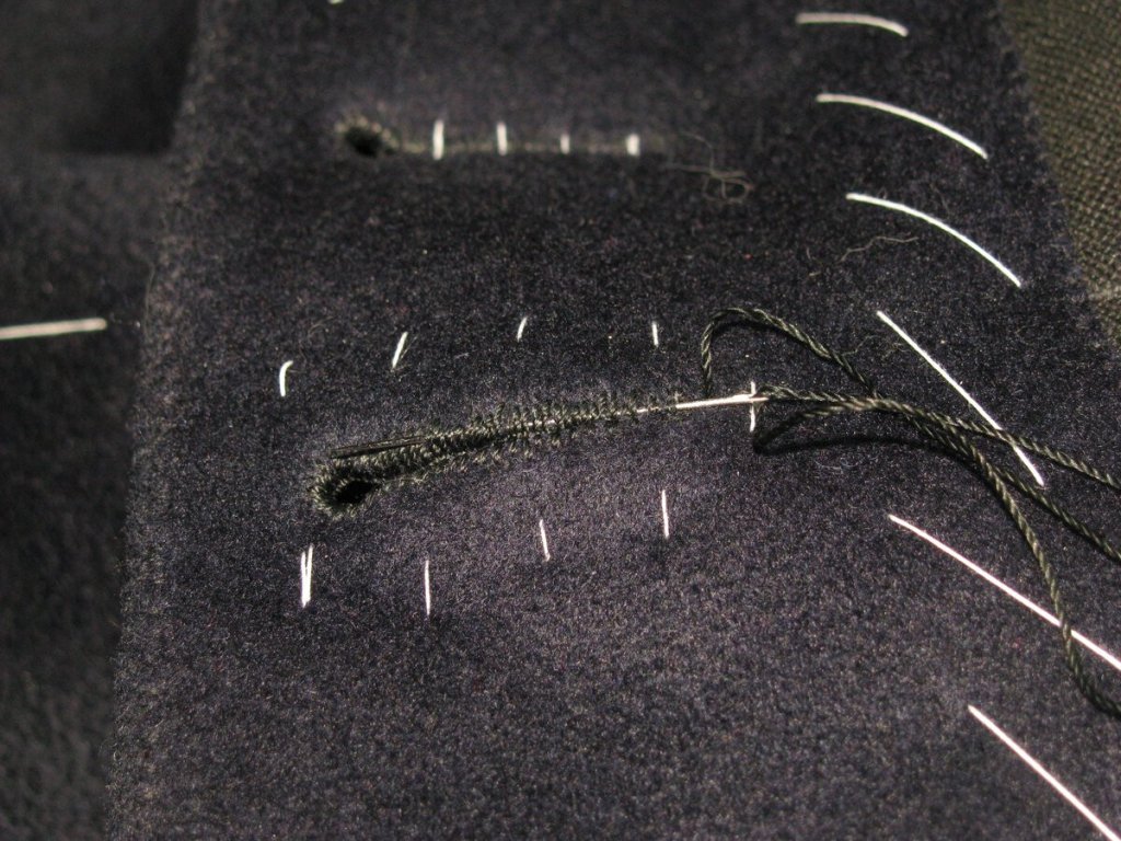 Secure the thread by passing it underneath the buttonhole stitching.
