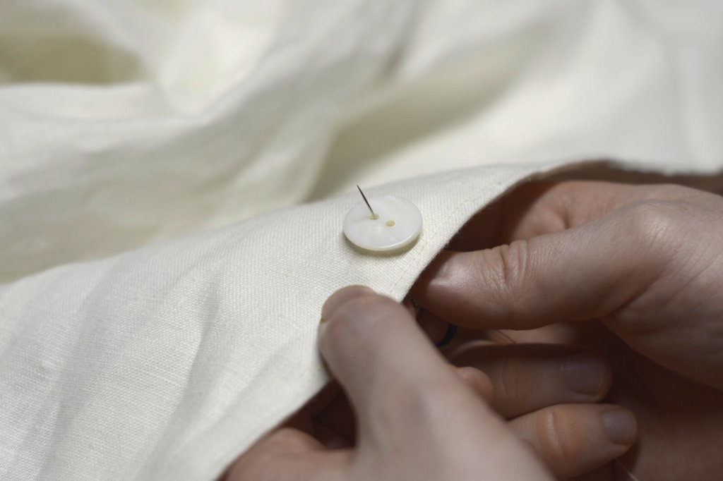 Sewing on a button.